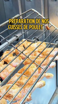 Cuisses de poulet assaisonnées en préparation sur une grille de rôtisserie dans un restaurant