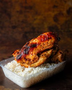 Poulet grillé servi avec du riz basmati dans un contenant transparent au restaurant MASTER POULET.