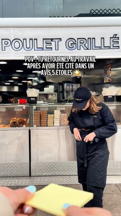 Restaurant rôtisserie avec comptoir en inox, poulets grillés bien visibles et employée en uniforme noir ajustant son tablier.