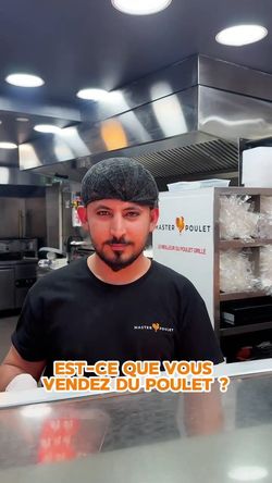 Employé portant un t-shirt Master Poulet dans une cuisine professionnelle de restaurant rôtisserie.