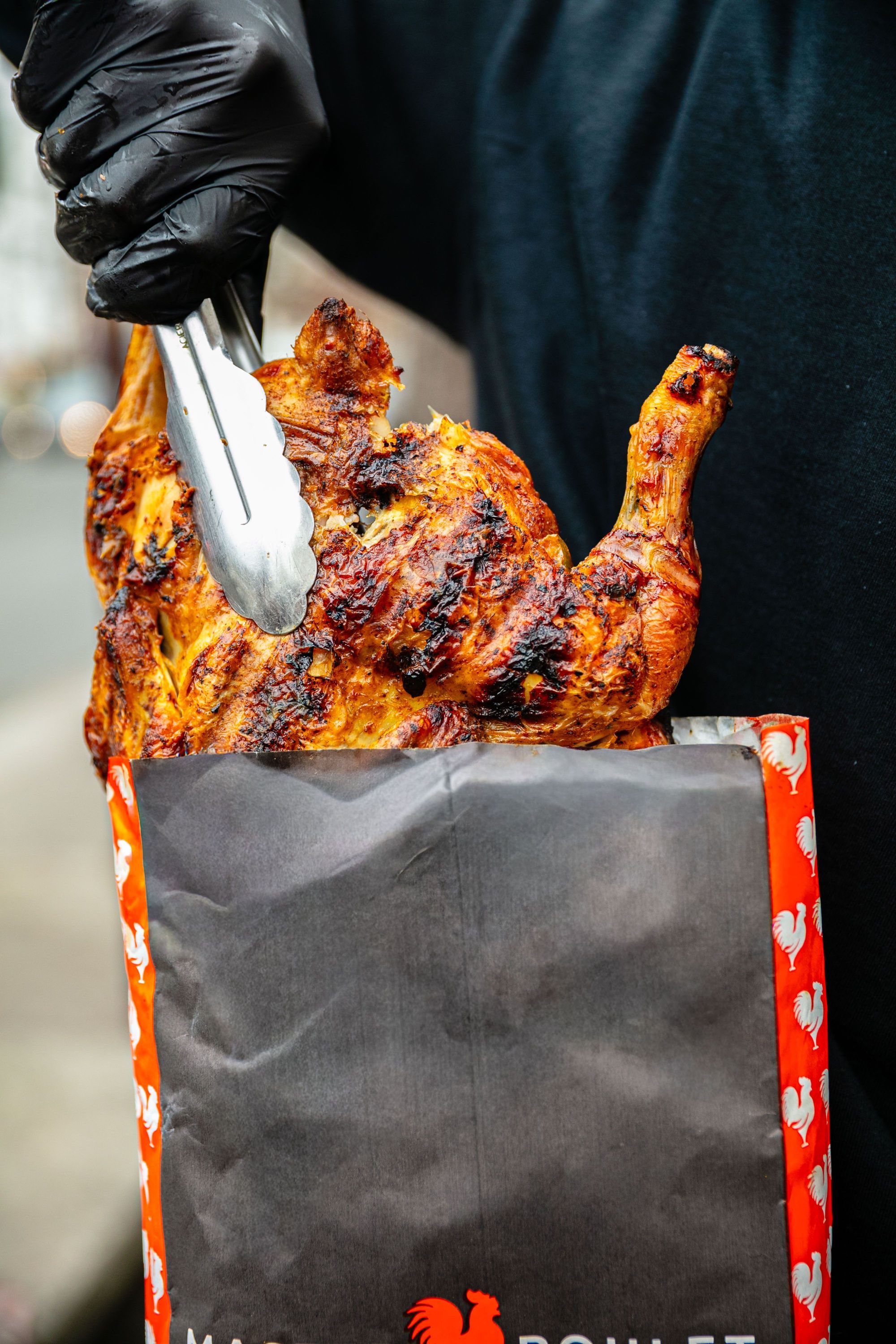 Poulet rôti à emporter, affichant une belle texture dorée et croustillante dans un sac de restaurant.